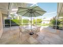 Screened patio with table, chairs, and umbrella at 338 Woodvale Dr, Venice, FL 34293