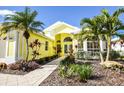 Beautiful yellow house with lush tropical landscaping and a welcoming entrance at 340 Bermuda Ct # 5, Venice, FL 34293