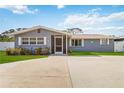 Ranch-style home with gray exterior, landscaping, and a driveway at 5172 Rolla Rd, Venice, FL 34293