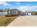 Gray house with screen porch, landscaping, and a long driveway at 5172 Rolla Rd, Venice, FL 34293