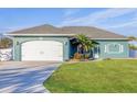 Curb appeal! Teal home with white garage door and lush lawn at 5298 Drew Rd, Venice, FL 34293