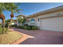 Side view of the house with a large driveway and landscaping at 746 Fringed Orchid Trl, Venice, FL 34293