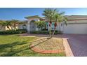 Landscaped front yard with brick pavers and palm trees at 746 Fringed Orchid Trl, Venice, FL 34293