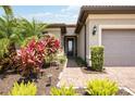 Welcoming walkway leading to front door, flanked by tropical plants at 13510 Esposito St, Venice, FL 34293