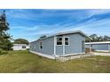 Well-maintained single-story home featuring blue siding, complemented by lush green lawn at 215 Portia N St, Nokomis, FL 34275