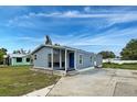 Inviting single-story home with blue siding, a covered porch, and a spacious driveway for easy parking at 215 Portia N St, Nokomis, FL 34275