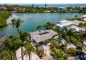 Aerial view of waterfront home featuring a private boat dock, lush landscaping, and tropical surroundings at 922 Casey Cove Dr, Nokomis, FL 34275