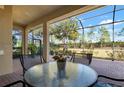 Covered patio with seating area, overlooking a lush green backyard at 115 Avalini Way, North Venice, FL 34275
