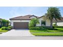Single-story house with a brown garage door and well-manicured lawn at 12619 Richezza Dr, Venice, FL 34293