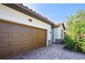 View of a brown double-car garage with a paved driveway at 12619 Richezza Dr, Venice, FL 34293