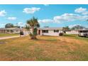 Landscaped yard with a white single-story house and driveway at 872 Mohawk Rd, Venice, FL 34293