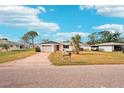 Front view of a white single story home with red door and a neatly kept lawn at 872 Mohawk Rd, Venice, FL 34293