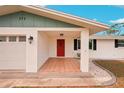 Covered front porch with tile flooring and red front door at 872 Mohawk Rd, Venice, FL 34293