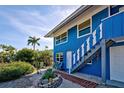 Blue house with brick pathway, and nicely landscaped yard at 113 Colonia W Ln, Nokomis, FL 34275
