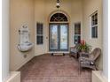 Front entry with double doors, fountain, and wicker chairs at 114 Medici Ter, North Venice, FL 34275