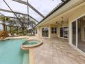Screened pool and spa with lounge chairs and lush landscaping at 114 Medici Ter, North Venice, FL 34275