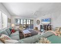 Bright living room featuring comfortable seating, a ceiling fan, and access to the screened porch at 1200 Tarpon Center Dr # 108, Venice, FL 34285