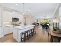 Open kitchen with white cabinets, island, and stainless steel appliances at 125 Soliera St, Nokomis, FL 34275