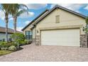 Tan house with a two-car garage and stone accents at 13280 Esposito St, Venice, FL 34293