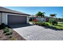 Gray paver driveway leading to a two-car garage at 2160 Bonito Way, Port Charlotte, FL 33953