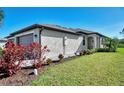 Tan house exterior with a two-car garage and landscaping at 2160 Bonito Way, Port Charlotte, FL 33953