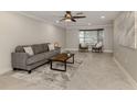 Living room features a grey couch, coffee table, and large windows at 2269 Lakewood Dr, Nokomis, FL 34275