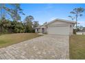 Contemporary house with a spacious paved driveway and attached garage at 2580 Sheila Ln, North Port, FL 34286