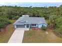 Single-story house with a gray roof, driveway and a large backyard at 419 Ramblewood St, Port Charlotte, FL 33953