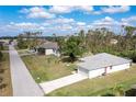 Bright aerial view of a charming single-story home with a well-maintained lawn and a long driveway at 6502 Whelan St, Englewood, FL 34224