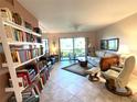 Bright living room with comfy seating, a bookcase, and access to a patio at 654 Bird Bay E Dr # 106, Venice, FL 34285