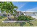 Landscaped front yard with palm trees and flowering bushes at 855 Morgan Towne Way, Venice, FL 34292