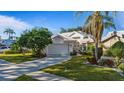 Front view of a single-Gathering home with a two-car garage and lush landscaping at 1009 Harbor Town Dr, Venice, FL 34292