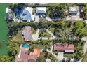 Bird's eye view showcasing multiple waterfront properties and lush landscaping at 107 Louella Ln, Nokomis, FL 34275