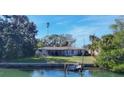Single-story waterfront home with private dock and expansive lawn at 107 Louella Ln, Nokomis, FL 34275