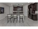 Modern kitchen with granite island, stainless steel appliances, and dark wood cabinets at 11601 Parrotfish St, Venice, FL 34292