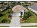 Property view showcasing home's exterior, landscaping, and a lake at 12198 Wakulla Pl, Venice, FL 34293