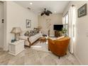 Cozy living room with tiled floors, comfortable seating, and a TV at 12198 Wakulla Pl, Venice, FL 34293