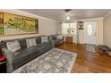 Living room features gray sofas, wood floors, and a large map print above the fireplace at 1300 Indus Rd, Venice, FL 34293