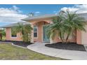Front entry of peach house with teal door at 13421 Gershwin Ln, Port Charlotte, FL 33981