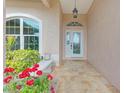 Front entrance with a tiled porch and red flowers at 1558 Belfry Dr, Venice, FL 34292