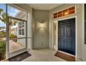Front entry with a screened porch and dark blue door at 1647 Lancashire Dr # 1647, Venice, FL 34293