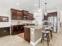 Modern kitchen with dark wood cabinets, granite countertops, and stainless steel appliances at 1675 Still River Dr, Venice, FL 34293