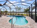 Relaxing kidney-shaped pool with a screened enclosure, overlooking a lake at 1675 Still River Dr, Venice, FL 34293