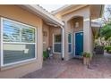 Home's front entry with teal door, brick pavers, and potted plants at 201 Auburn Woods Cir, Venice, FL 34292