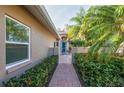 Brick walkway to teal front door, lush landscaping and gated entry at 201 Auburn Woods Cir, Venice, FL 34292