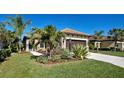 Single-story house with palm trees and well-manicured lawn at 295 Cassano Drive, Nokomis, FL 34275
