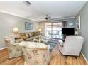 Living room with hardwood floors, balcony access, and seating at 380 Three Lakes Ln # F, Venice, FL 34285