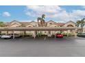 Exterior view of condo building with covered parking and cars at 4200 Castlebridge Ln # 1924, Sarasota, FL 34238