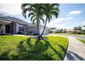 Landscaped yard with palm trees and curb appeal at 521 Pennyroyal Pl, Venice, FL 34293