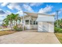 Front view of a white mobile home with palm trees at 552 Fleetwood St, North Port, FL 34287